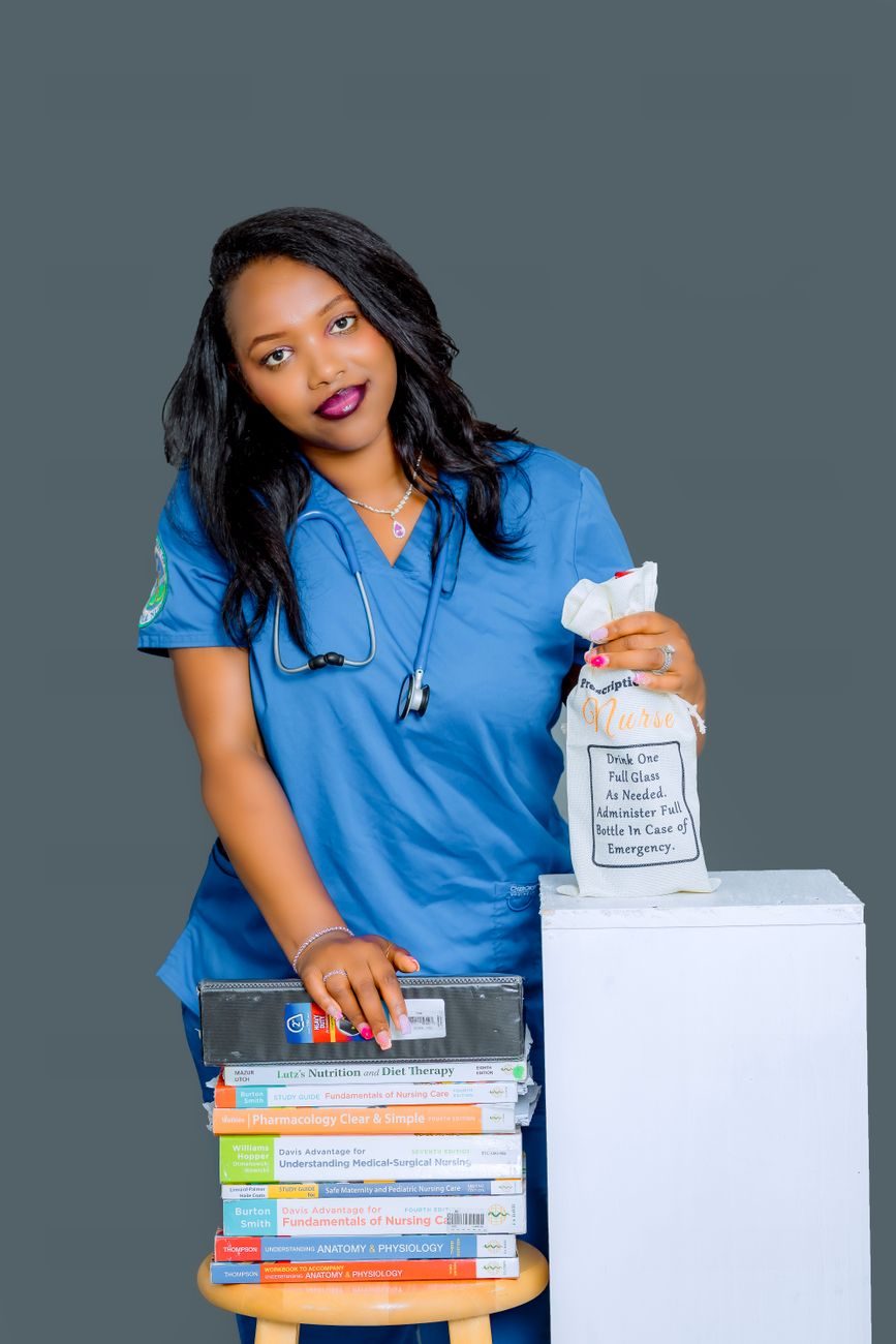 A nurse in blue scrubs with a stethoscope beside a stack of medical textbooks